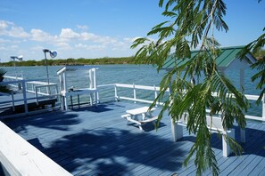 A wooden deck with picnic tables and a covered seating area overlooking a body of water. - The hill private fishing pier NOT water front (Rio Hondo)