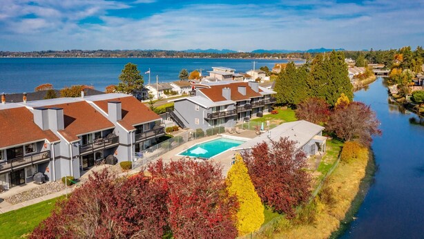 Zona residencial junto al lago con casas modernas, una piscina y vistas al lago.