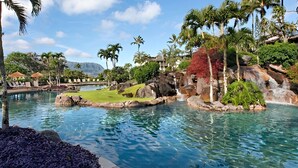 A resort pool with clear water, surrounded by tropical vegetation and a waterfall. - Hanalei Bay Resort-A/C, Beach, Bali Hai Views from 3 Lanai's, Washer & Dryer (Princeville)