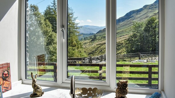 A room with a large window offering a view of a mountainous landscape.