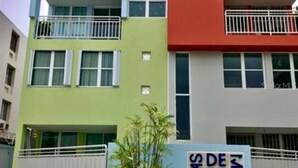 A multi-story building with balconies, a sign indicating it's a condominium, and a small plant in front. - Walk to beach & Kioskos, close to rainforest, cold air, free parking  (Luquillo)