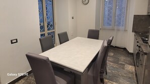 A dining area with a table and chairs, a clock on the wall, and a window with a view of the outside. - 5 minutes walk from saint peter vatican museums castel sant angelo. At 50m meter (Roma)