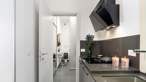 A modern kitchen with a stainless steel stove, a black range hood, and a white sink. - Lovely home in Calci (PI) (Calci (PI))