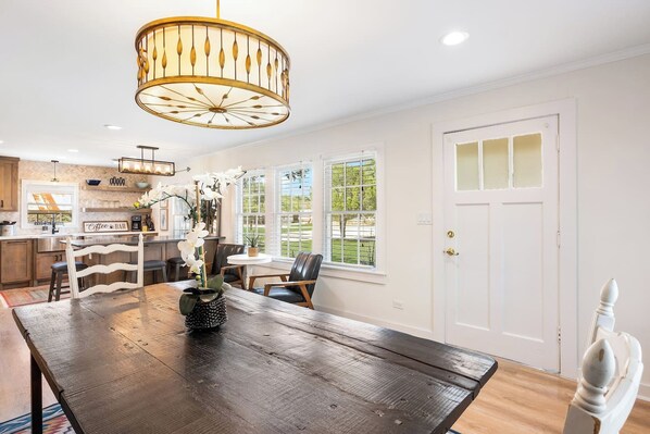 A dining area with a wooden table, chairs, and a chandelier.