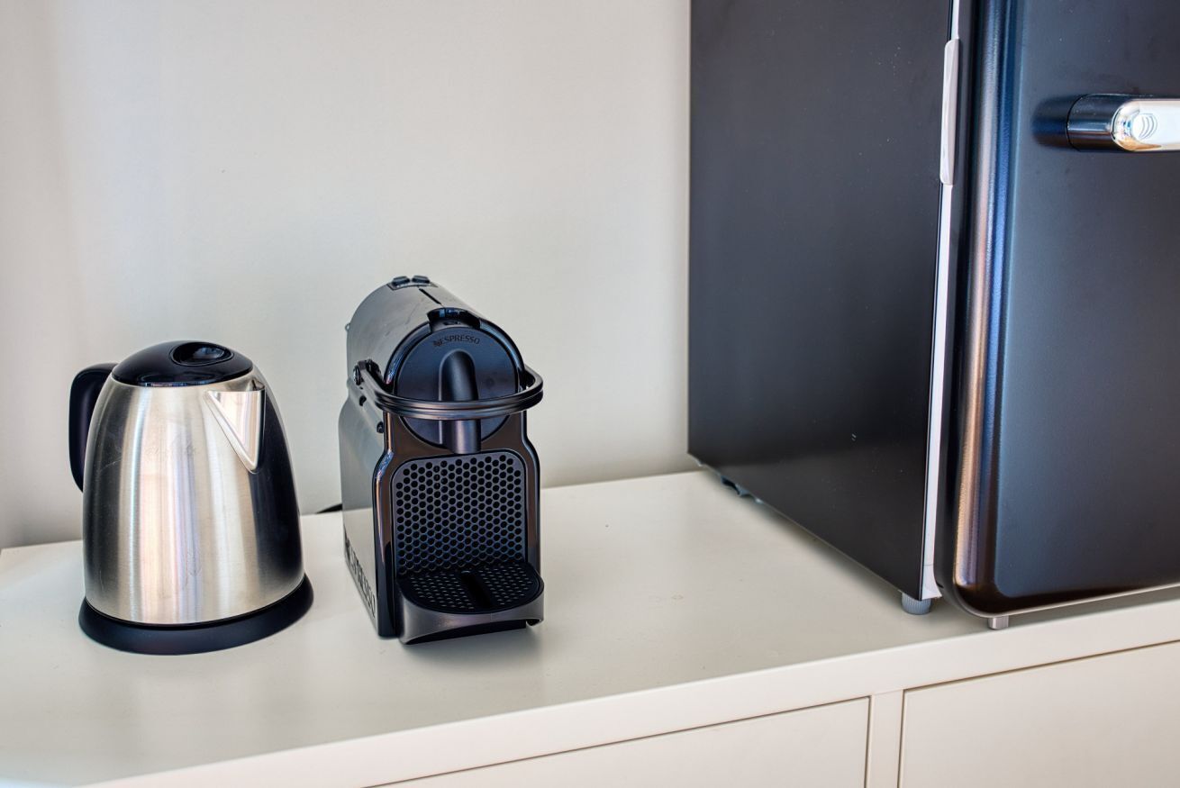 A stainless steel kettle and a coffee maker on a countertop.