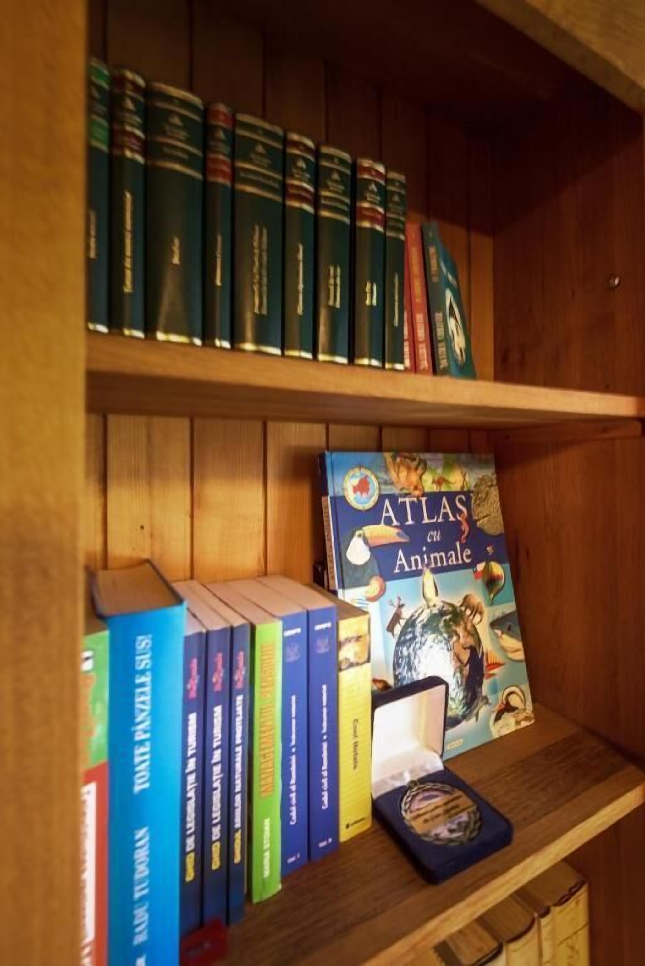 Uma estante com vários livros, incluindo um exemplar notável de 'Atlas en Animal'.