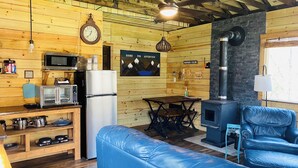 Interior acollidor d'una cabana amb cuina, menjador i seients.