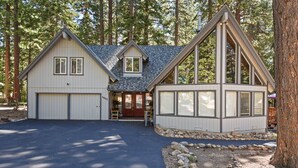 A two-story house with a garage, a covered porch, and a stone foundation.