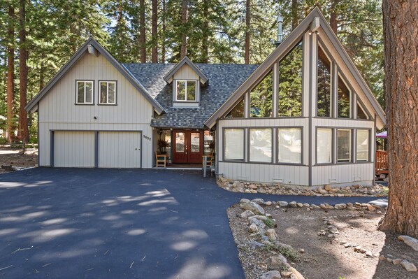 A two-story house with a garage, a covered porch, and a stone foundation. - 5-Bedroom Agate Bay Home, Lake & Skiing (Carnelian Bay)