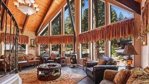 A spacious living room with large windows, a fireplace, and a cozy seating area.