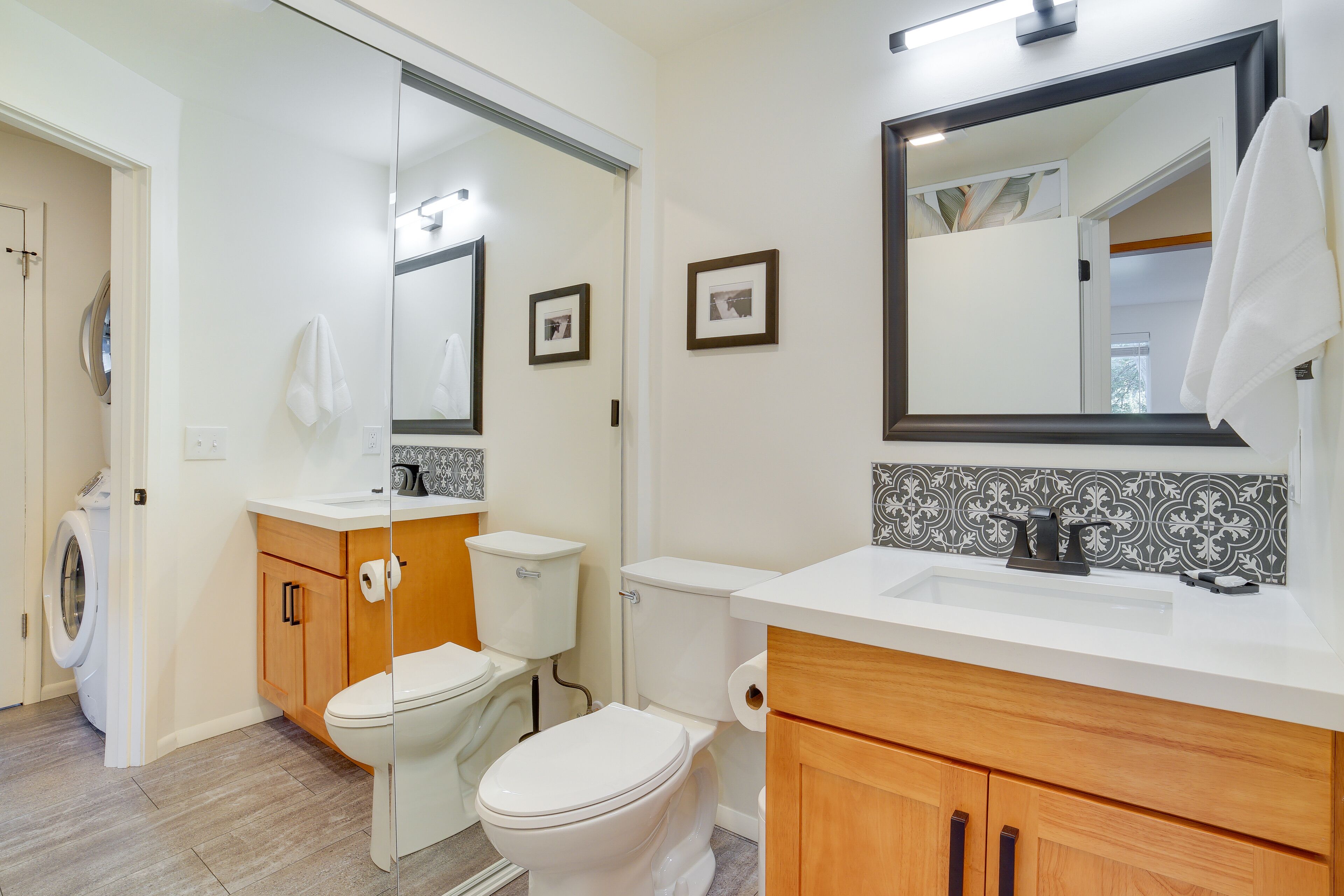 Une salle de bain moderne avec des toilettes, un lavabo et un miroir.