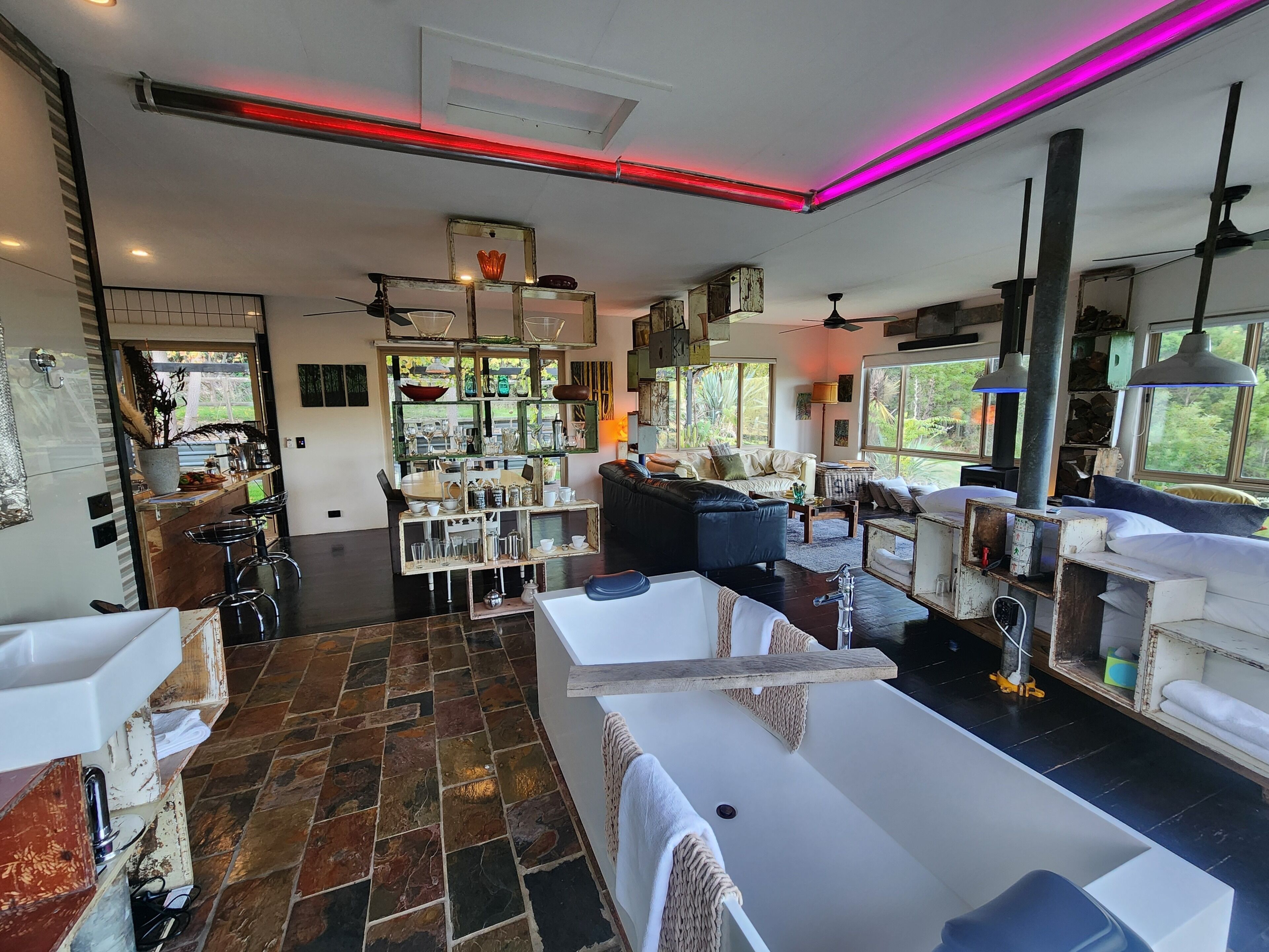 A spacious living area with a large window, a fireplace, and a dining area with bar stools.