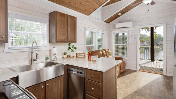 A modern kitchen with wooden cabinets, stainless steel appliances, and a large island. - Waterfront Luxury Tiny Home 360 North on Wilson Lake Close to Robert Trent Jones (Muscle Shoals)
