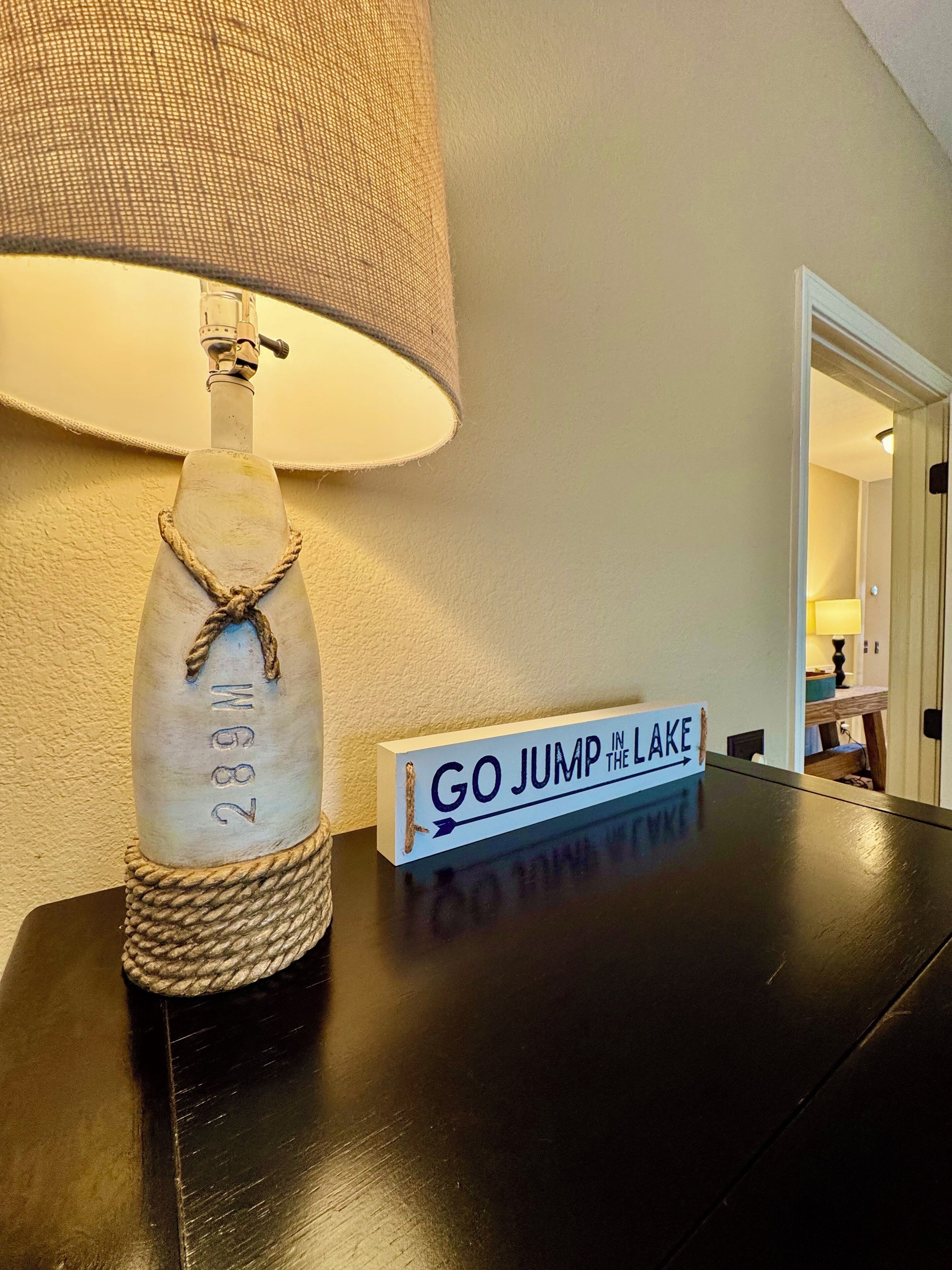 Une lampe dotée d’une anse en corde et d’une inscription qui dit : « ALLEZ VOUS Y FROTTER ! »