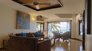 A spacious living area with a brown sofa, a coffee table, and a painting on the wall.