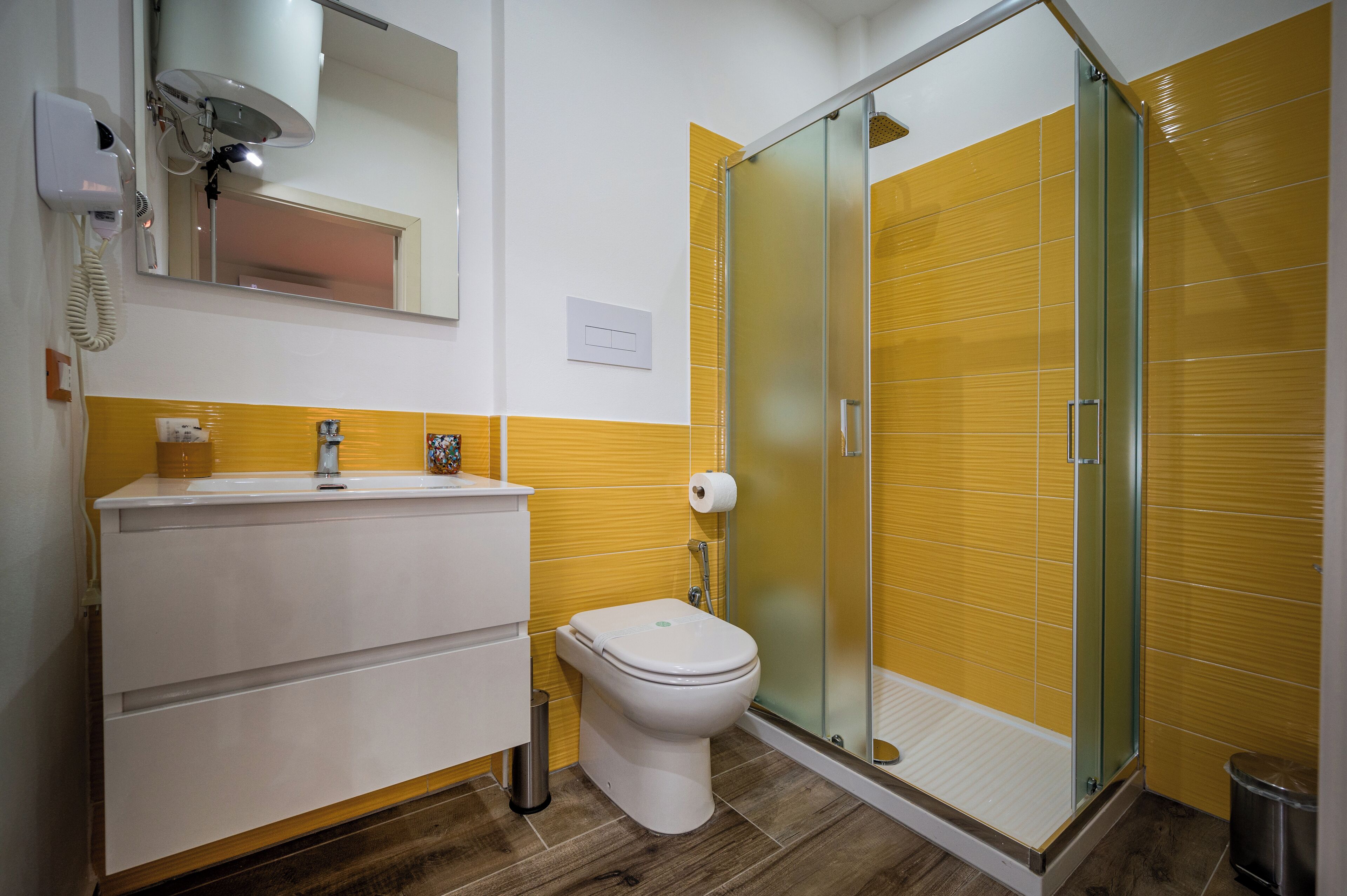 Ein Badezimmer mit Toilette, Waschbecken und einer Duschkabine aus Glas.