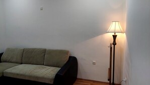 Un soggiorno con un divano e una lampada da terra.