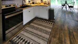 A tented kitchen with white cabinets, a microwave, and a chandelier.