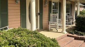 A house with a porch, green shutters, and a number '105' on the door. - Tupelo house near mall (Saltillo)