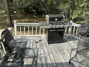 A deck with a grill, two metal chairs, and a bench. - Tupelo house near mall (Saltillo)