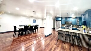 Een ruime keuken met een centraal eiland, moderne apparaten en blauwe kastjes.