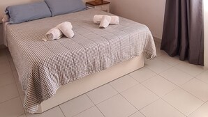Ein Schlafzimmer mit Bett, Kissen, einem Nachttisch und einer Wanddekoration.