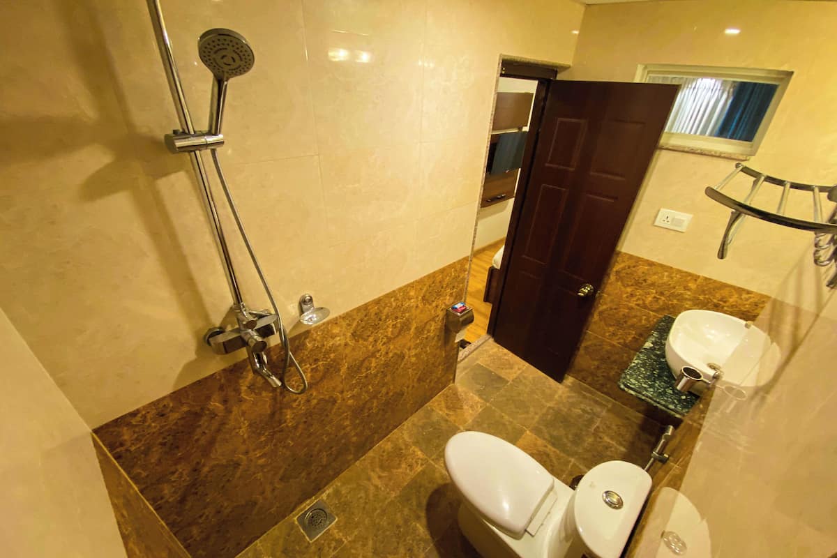 A bathroom with a shower, toilet, and sink.
