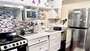 Une cuisine moderne équipée d’une cuisinière, d’un four à micro-ondes, d’un four, d’un réfrigérateur et d’une machine à café.