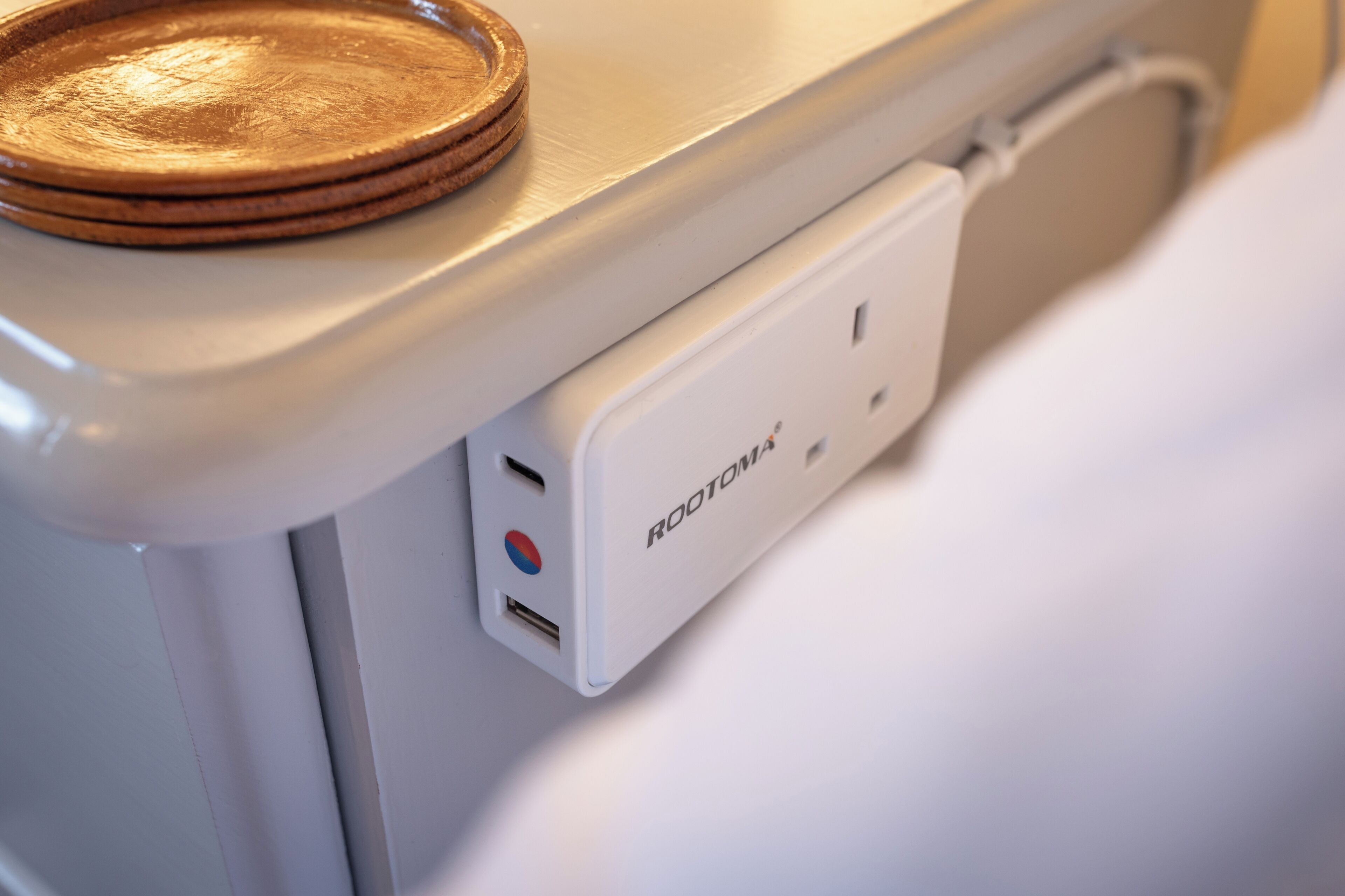 Ein weißes elektronisches Gerät mit einem USB-Anschluss und einem Logo mit der Aufschrift 'ROOTOMAX'.