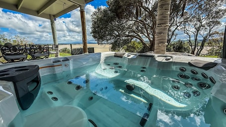 Outdoor spa tub. Riverfront Family Home, with spa and stage