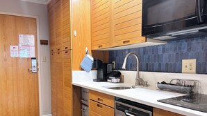 Een moderne keuken met houten kastjes, roestvrijstalen apparatuur en een betegelde achterwand.