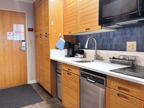 A modern kitchen with wooden cabinets, stainless steel appliances, and a tiled backsplash. - The ultimate ski studio at Keystone!  Upgraded with a premium king size bed. (Keystone)