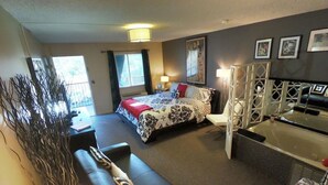 Una habitación de hotel con cama, sofá, escritorio y bañera.