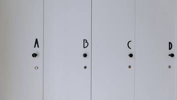 A set of four white lockers with black handles and screws, labeled A, B, C, and D.