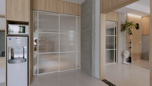 A modern kitchen with a built-in water dispenser and a large, frosted glass door. - terumahouse (Taitung)