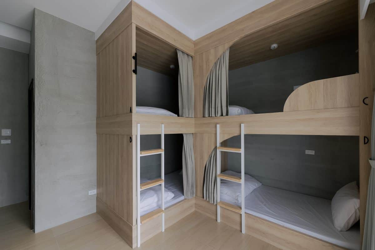 A room with a bunk bed, a wardrobe, and a door.