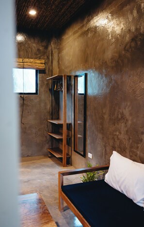 Una habitación con un banco de madera, una repisa en la pared y un ventanal.