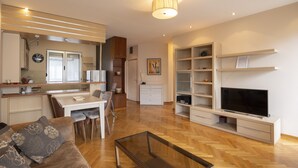 A modern living room with a television, sofa, coffee table, and dining area. - Belgrade Center Apartment  Lux II (Belgrade)