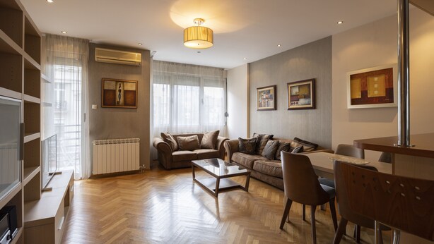 A modern living room with a sofa set, a coffee table, and a dining table. - Belgrade Center Apartment  Lux II (Belgrade)