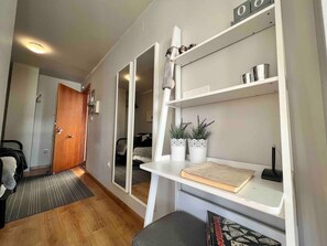 Enter a serene bedroom with a large bed and comfortable nightstand, featuring a lamp and decorative shelves.
