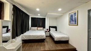 Habitación de hotel con dos camas, un escritorio, una silla, un espejo, un cuadro y una puerta.