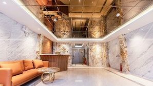 A spacious lobby with a marble floor, a reception desk, a sofa, and a glass ceiling. - My My Hotel 2 (Ho Chi Minh City)