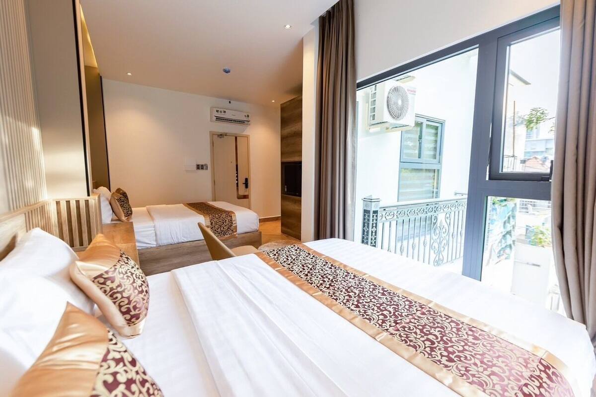 Een hotelkamer met twee bedden, een groot raam met uitzicht en een airconditioning aan de muur.