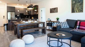 Una cocina moderna con armarios oscuros, una isla central e iluminación colgante.