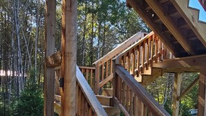A wooden staircase leading up to a covered area with a view of trees. - Hot Tub, Lake Front, NEW Game Rm, Fire Pit, Kayaks (Eureka Springs)