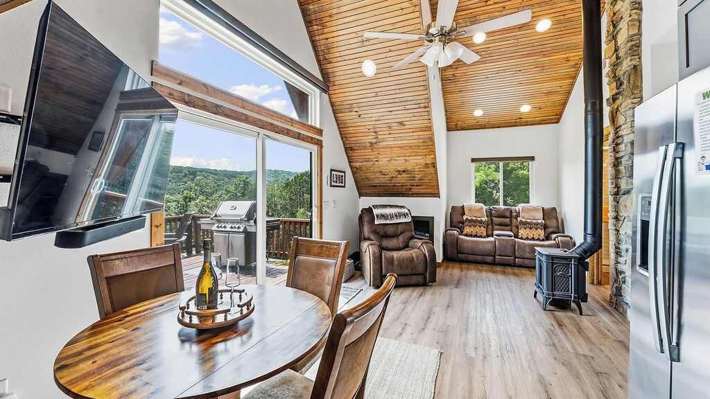 Un intérieur moderne comprenant un coin repas, des sièges et une vue dégagée grâce à de grandes fenêtres.