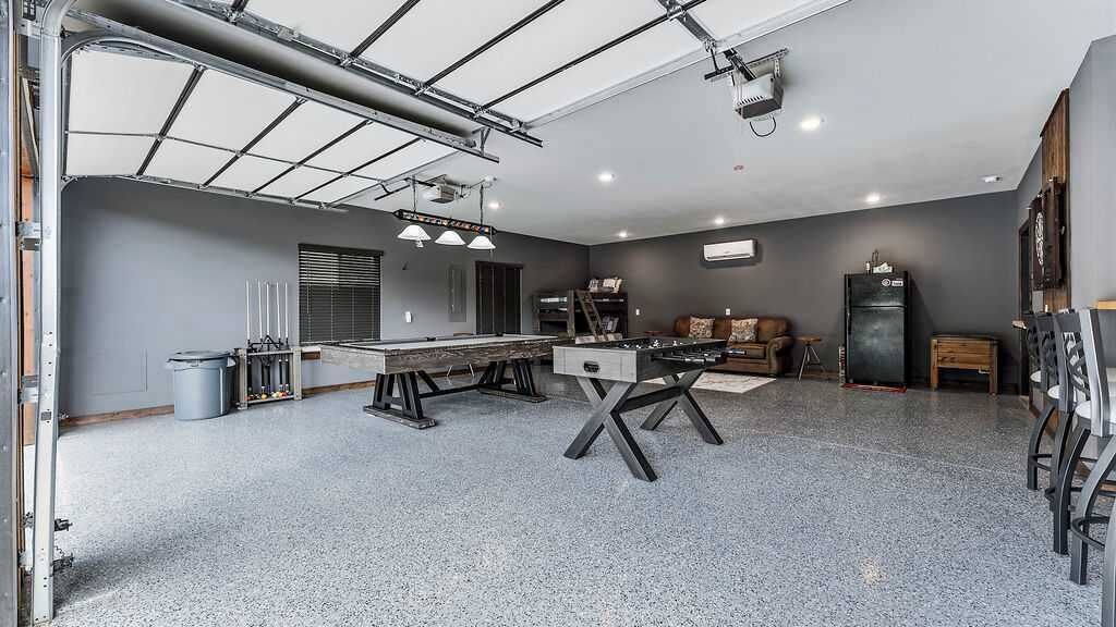 A spacious room with a large dining table, a sofa, and a refrigerator.