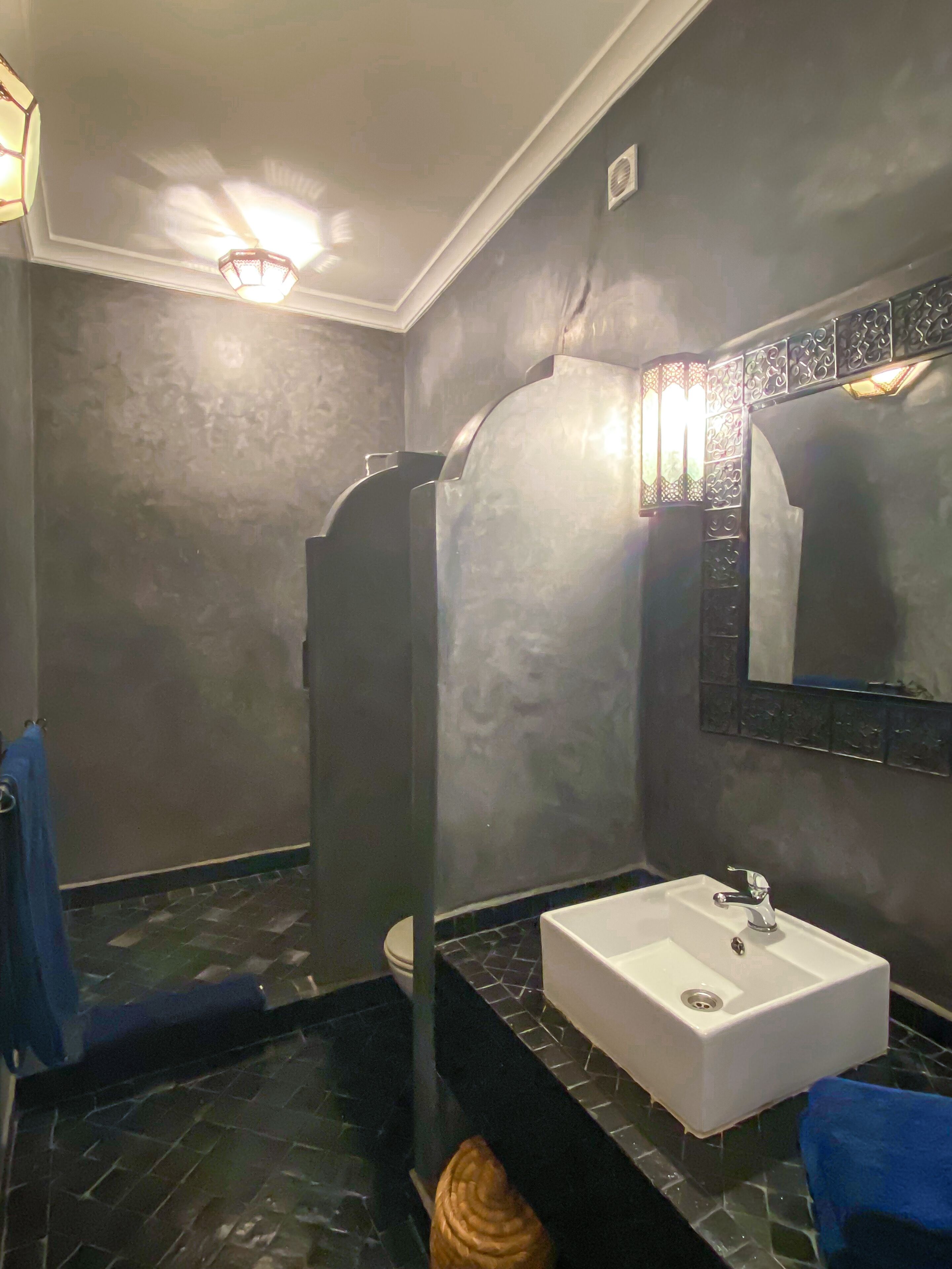 Ein Badezimmer mit einem weißen Waschbecken, einem Spiegel und einer Dusche.