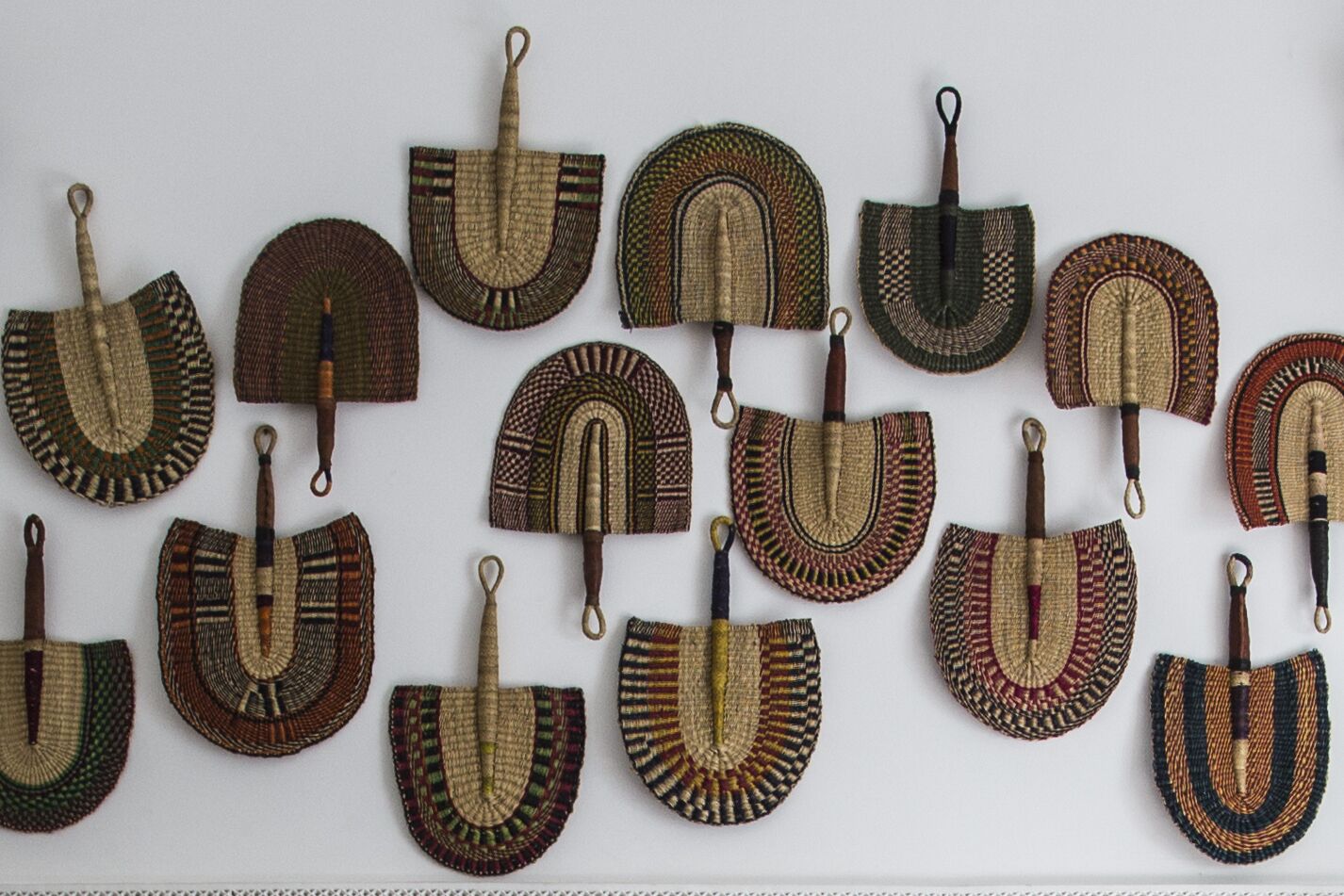 A collection of woven baskets with handles, displayed against a plain background.