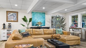 A modern living room with a leather sectional sofa, a coffee table, and a decorative peacock sculpture.
